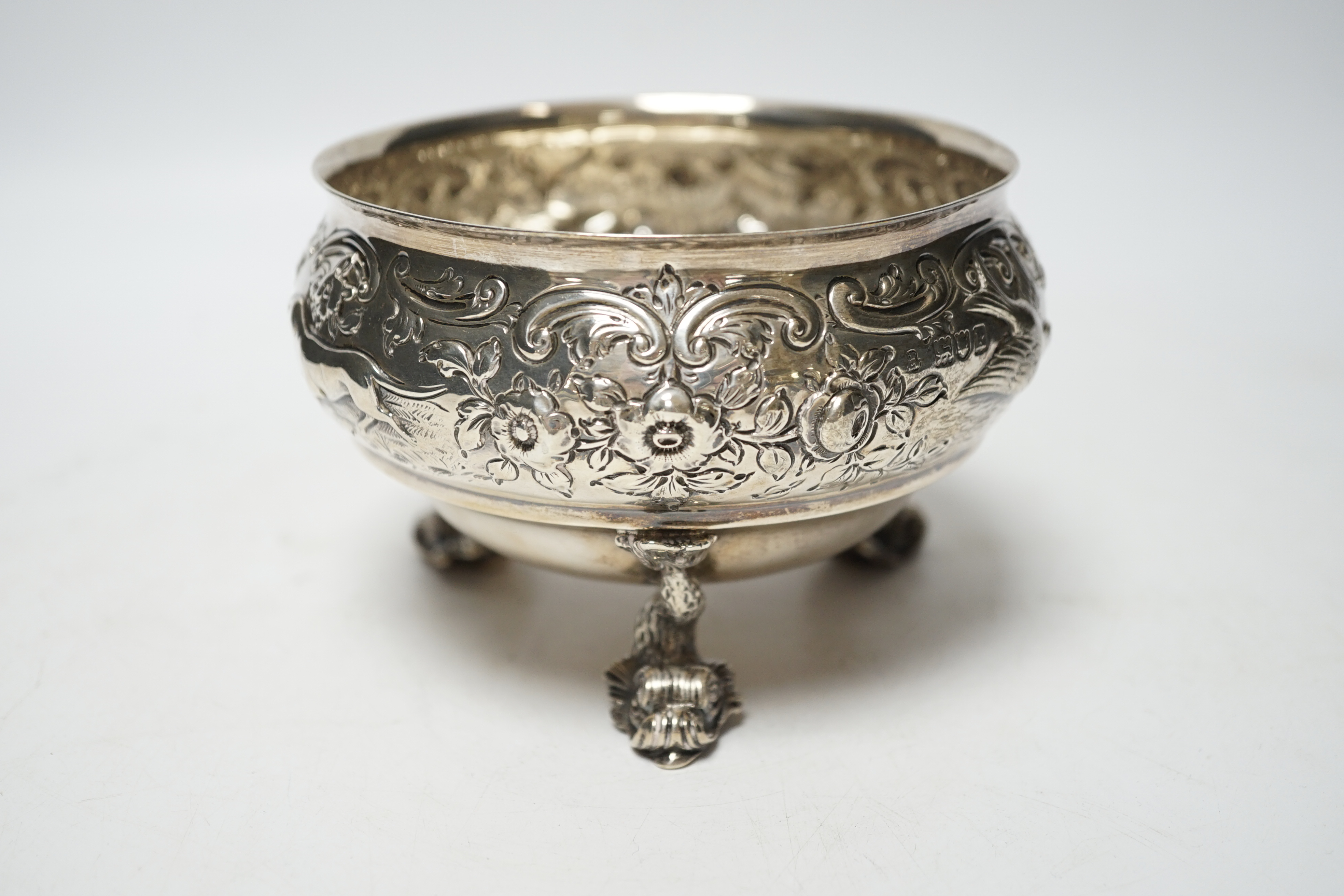 An Edwardian embossed silver bowl, on three dolphin supports, Wakely & Wheeler, London, 1905, diameter 11.6cm, 11.4oz.